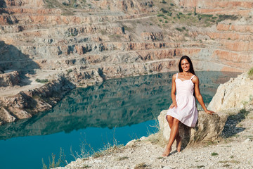 Beautiful woman in dress looks at the view of a mountain lake
