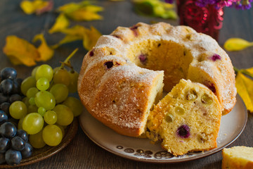 Homemade bundtcake with autumn grapes on a table with fall decoration