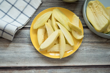 Sliced sour yellow mangoes on yellow dish