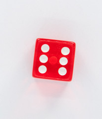 A red dice with the number six to play