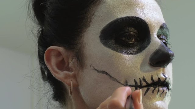 Woman finishing Day of the Dead,Halloween makeup