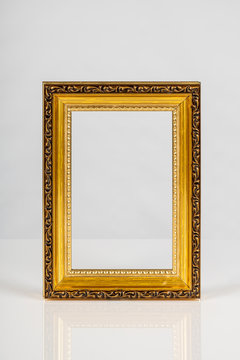 One beautiful old antique empty wooden gold frame on white background.