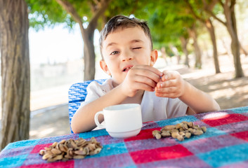 Happy arabic enjoyong eating pistachio in the park outdoor