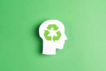 Head profile silhouette with recycle symbol on green background.