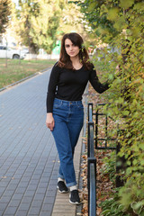 Young beautiful girl in the sunset light on a city street
