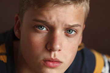 Portrait of the face of a young man with blond hair and blue eyes