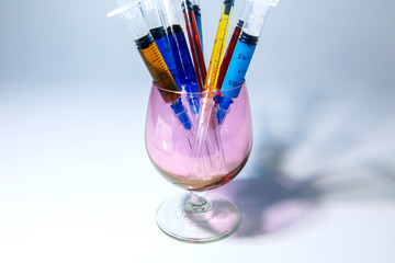Set of medical syringes in a glass with colored injections for cosmetology. The concept of cosmetology by various infections
