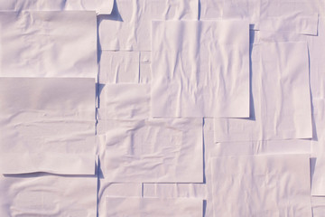 Square sheets of white paper glued to the wall.
