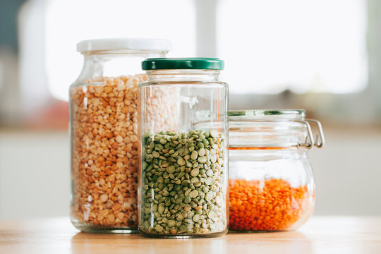 Glass jars with beans in the minimalistic interior. Peas and lentils as sources of vegetable protein. Zero waste concept, plastic-free, eco-friendly shopping, vegan - Powered by Adobe