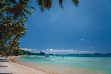 El Nido, Palawan, Philippines. Beach coastline. Shallow lagoon, sandy beach with palm trees. Travel and vacation concept