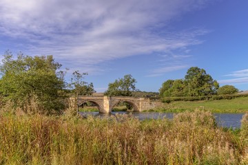 Fototapeta na wymiar An old bridge crosses the River Derwent.