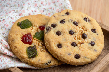 Mixed fruits cookie and Chocolate chip with wooden tray on the wood table. Delicious homemade baked cookie.
