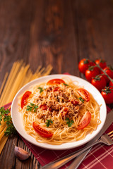 Pasta bolognese with tomato sauce and minced meat, grated parmesan cheese and fresh parsley - homemade healthy italian pasta on rustic wooden background.