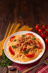 Pasta bolognese with tomato sauce and minced meat, grated parmesan cheese and fresh parsley - homemade healthy italian pasta on rustic wooden background.