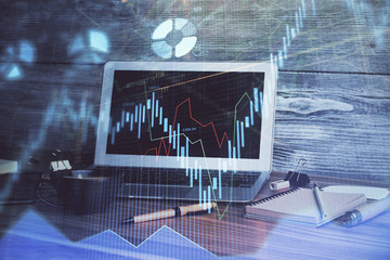 Financial chart drawing and table with computer on background. Multi exposure. Concept of international markets.