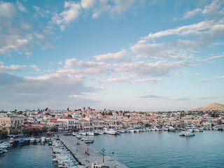 Aerial drone bird's eye view of famous and picturesque port of Aegina island with fishing boats docked and Yachts, Saronic gulf, Greece