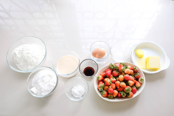 Vanilla flour, butter, milk, sugar, eggs and strawberries as raw materials for baking
