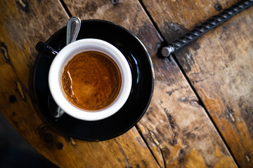 Hot coffee cup with premium arabica coffee beans on the wooden table.