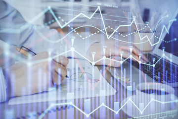 Multi exposure of stock market graph with man working on laptop on background. Concept of financial analysis.