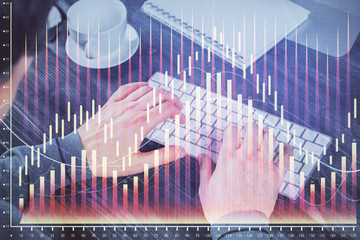 Multi exposure of graph with man typing on computer in office on background. Concept of hard work.