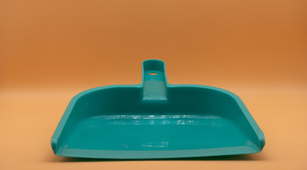 Green small dustpan To clean in the house With an orange backdrop