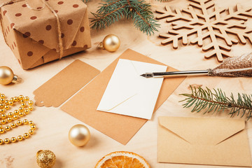 Greeting letter, envelope and feather  surrounded by Christmas decorations