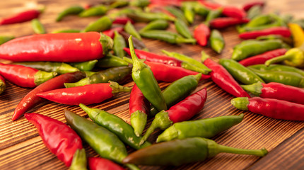 Green and red chili peppers on a wooden board