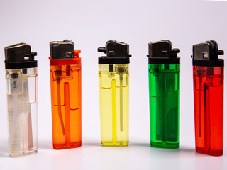 five gas lighters in different colours on a white background