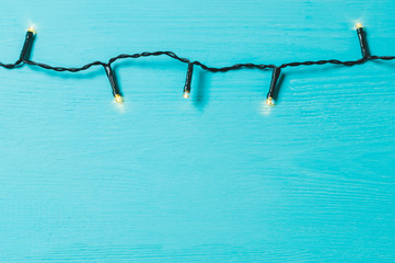blue wooden background with lights lights garland