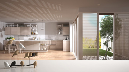 White table top or shelf with minimalistic bird ornament, birdie knick - knack over blurred contemporary white and wooden kitchen with island and stools, modern interior design