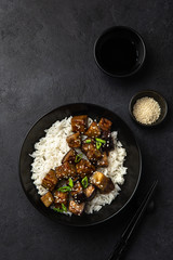 roasted teriyaki eggplant with rice in black bowl
