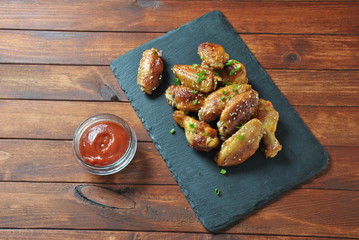 Grilled, barbecue chicken wings, tasty food for dinner or lunch. Fried chicken wings with sesame seeds. Fast food concept