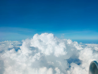 Sunrise above clouds from airplane window. Bright blue sky top horizontal view copyspace. Travelling concept View of the engine.