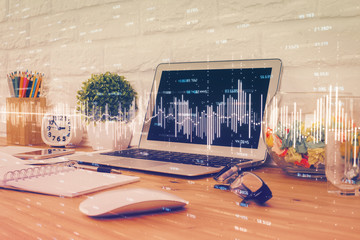 Double exposure of graph and financial info and work space with computer background. Concept of...
