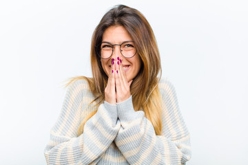 young pretty woman happy and excited, surprised and amazed covering mouth with hands, giggling with...