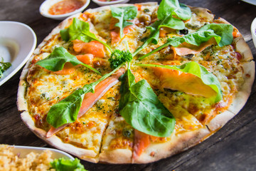 Salmon Pizza and Green Vegetables on a wooden table