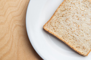 Sliced bread on white dish, wood background