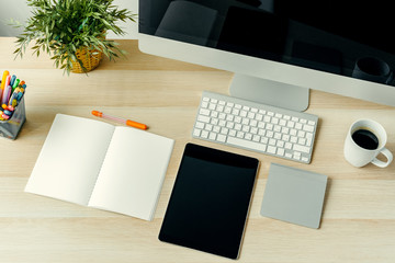 Top view of working table  with computer, notepad, coffee cup and supplies