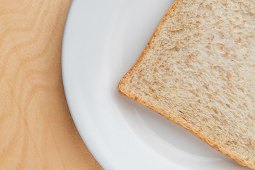 Sliced bread on white dish, wood background