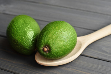 Whole fresh avocado in wooden spoon on dark vintage table background - Image