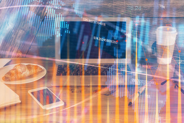 Double exposure of chart and financial info and work space with computer background. Concept of international online trading.