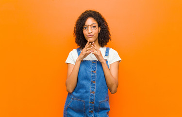 young pretty black woman scheming and conspiring, thinking devious tricks and cheats, cunning and...