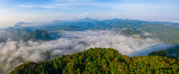 Aerial view of mountains with cloud cover mountain at sunrise and blue sky in Surat Thani Province, Thailand.