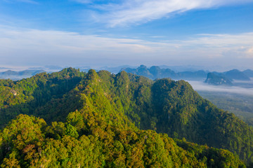 Aerial view of mountains with cloud cover mountain at sunrise and blue sky in Surat Thani Province, Thailand.