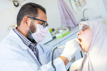 Dentist treating his patient teeth from ache