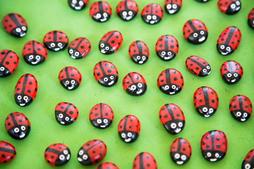 Close up shot of ladybugs painted with acrylic paint on a green mat.