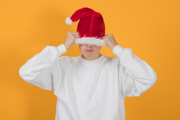 Fototapeta na wymiar young teenage man with santa claus hat isolated on color background