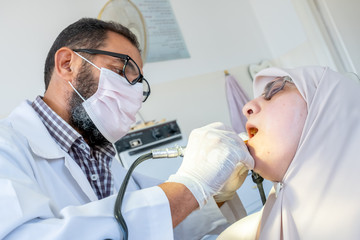 Dentist treating his patient teeth from ache