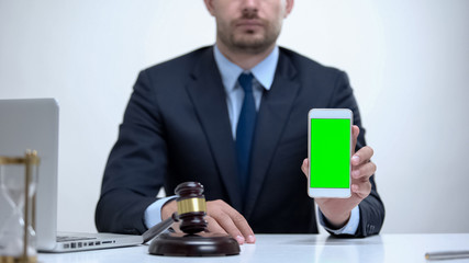 Confident attorney holding green screen cellphone, constitutional law mobile app