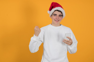 young teenage man with santa claus hat isolated on color background